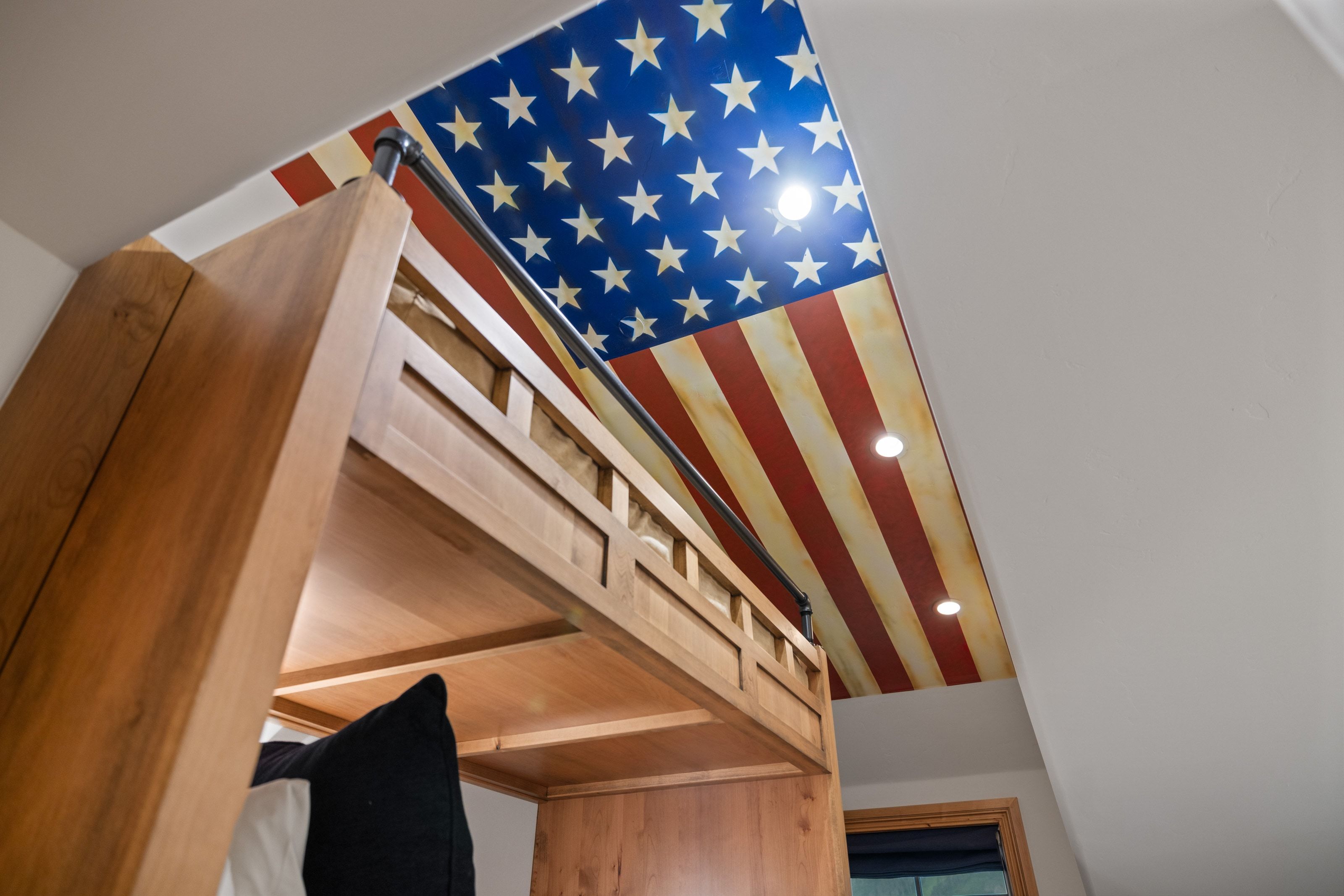Built-in wood-finish loft bed with a metal safety rail