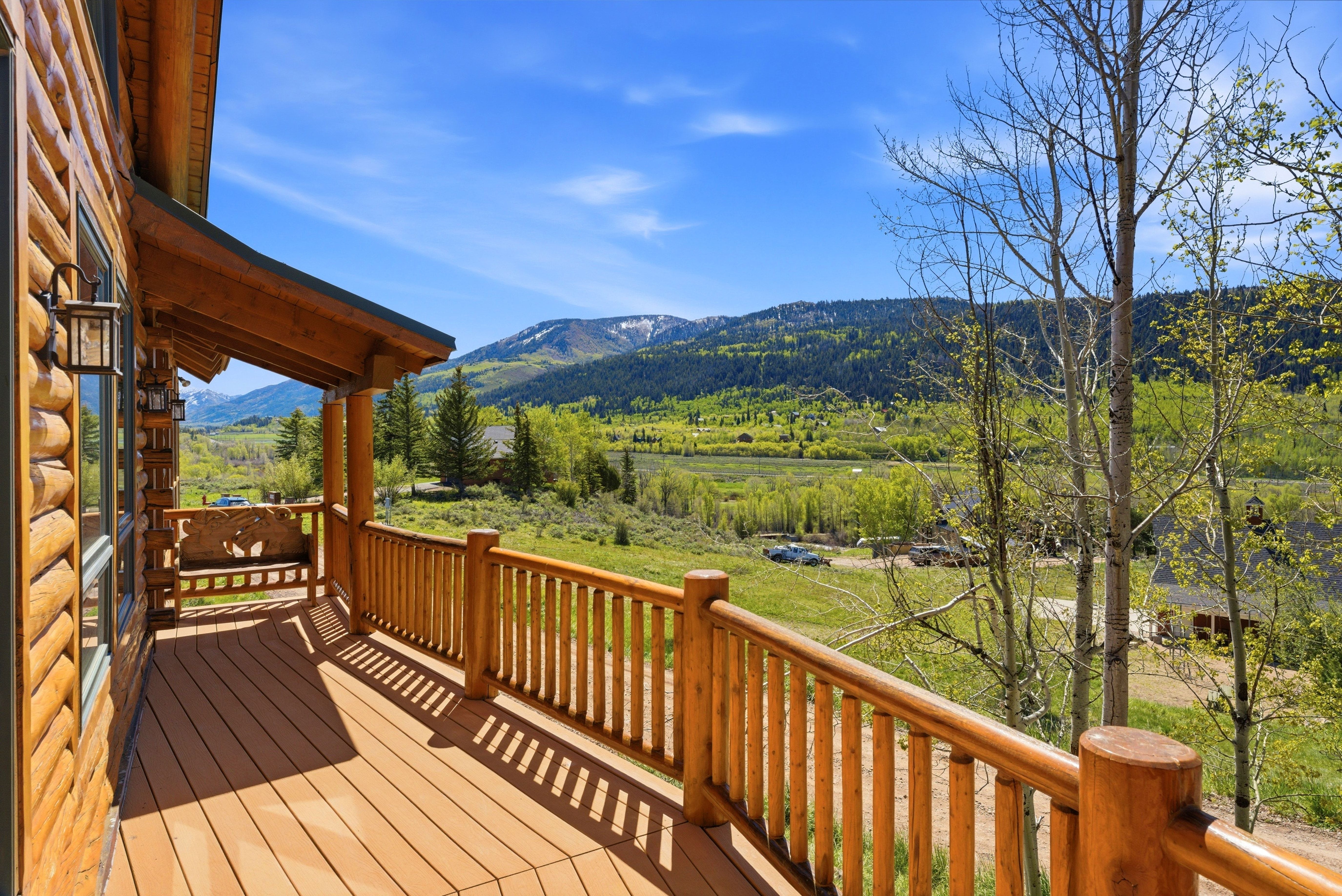 Spacious wood-finish deck with a log railing system and a built-in wooden bench