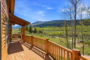 Spacious wood-finish deck with a log railing system and a built-in wooden bench