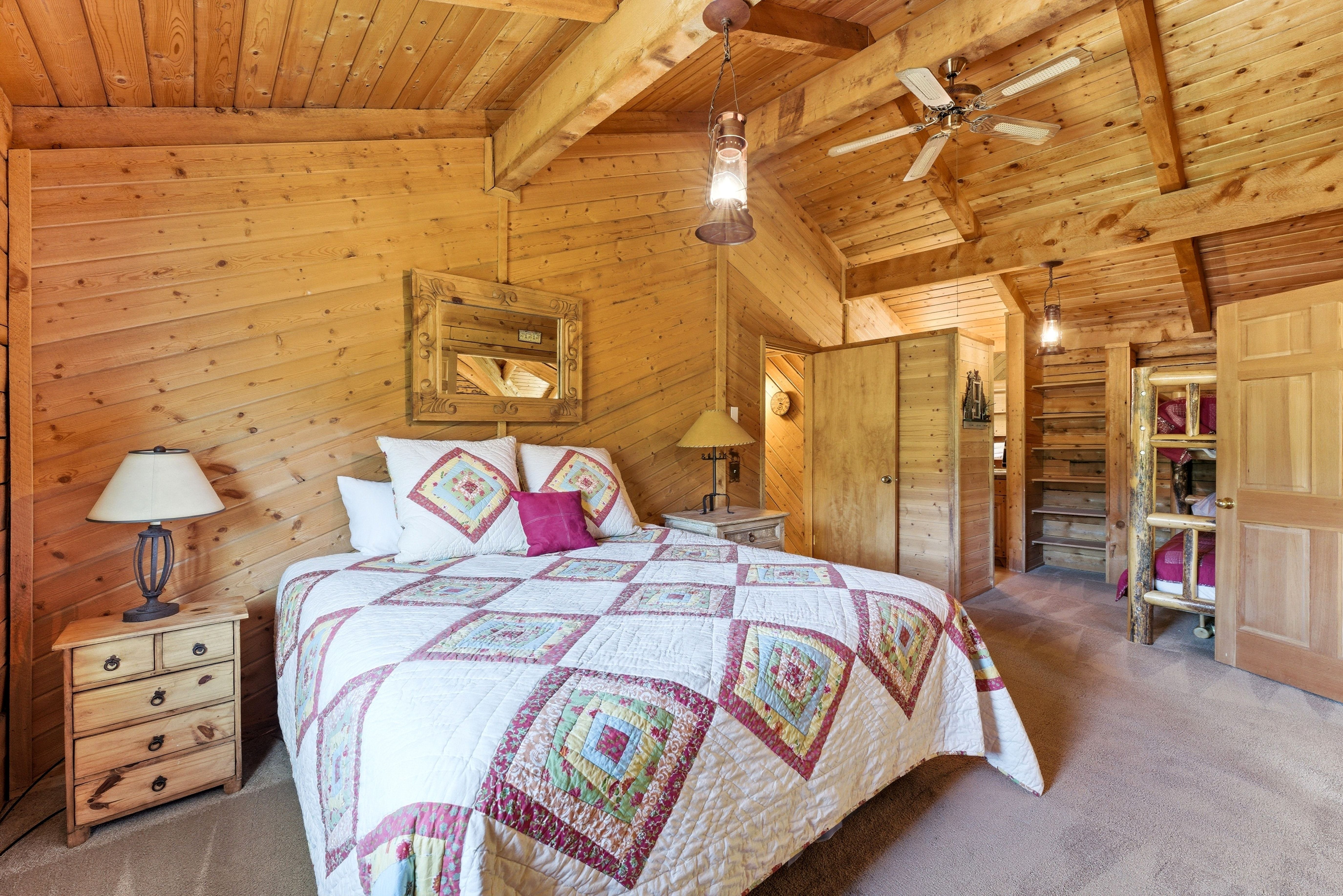 Wood-paneled room featuring vaulted ceilings with exposed beams, an overhead ceiling fan, and recessed lighting