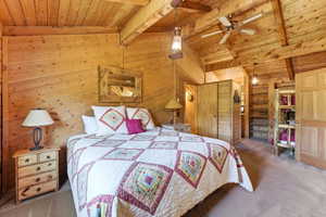 Wood-paneled room featuring vaulted ceilings with exposed beams, an overhead ceiling fan, and recessed lighting