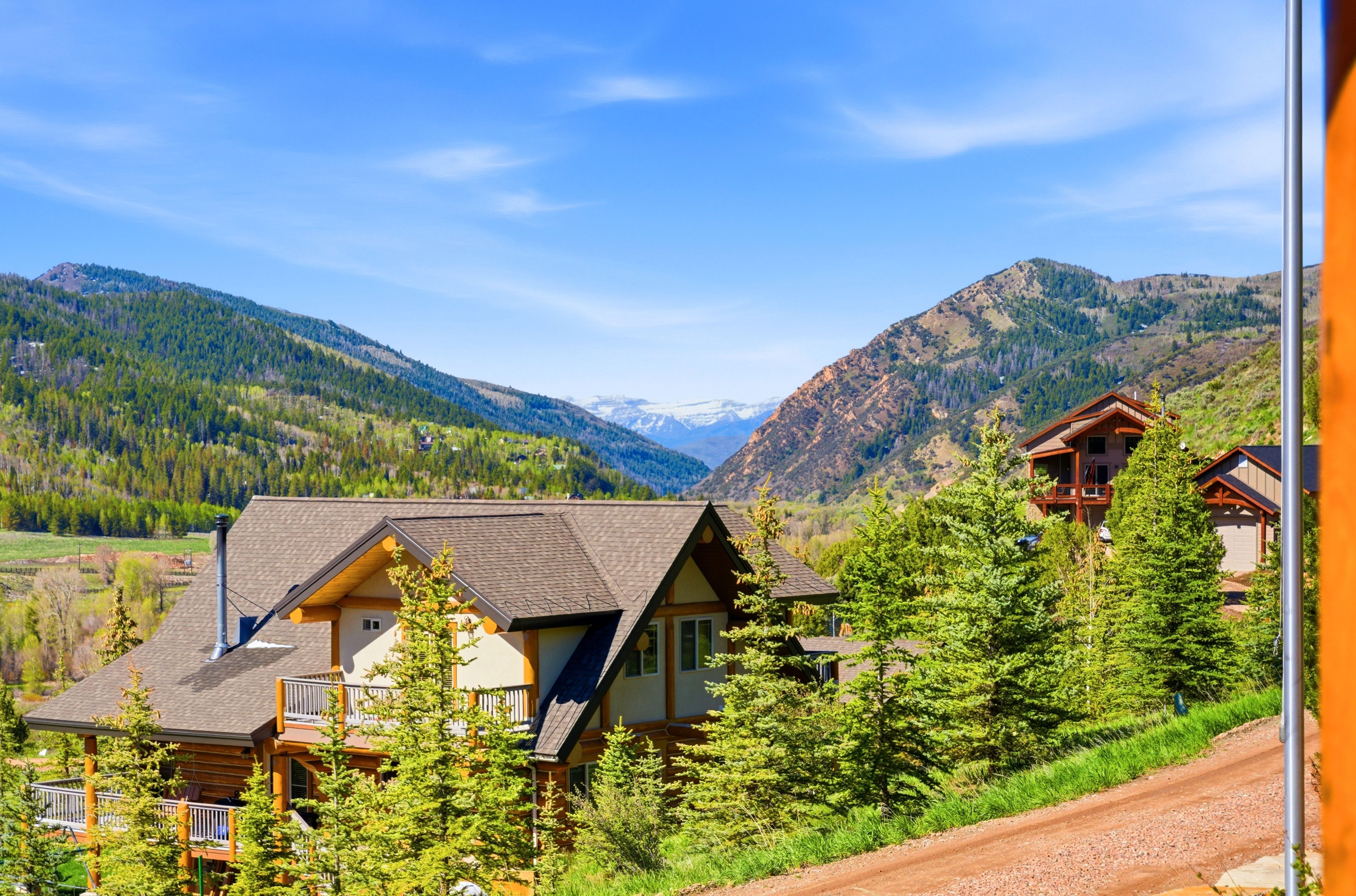 Rustic-style mountain home featuring a pitched roof, multiple balconies, and natural wood and stucco siding