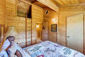 Wood-paneled room featuring a built-in ladder accessing an overhead loft space