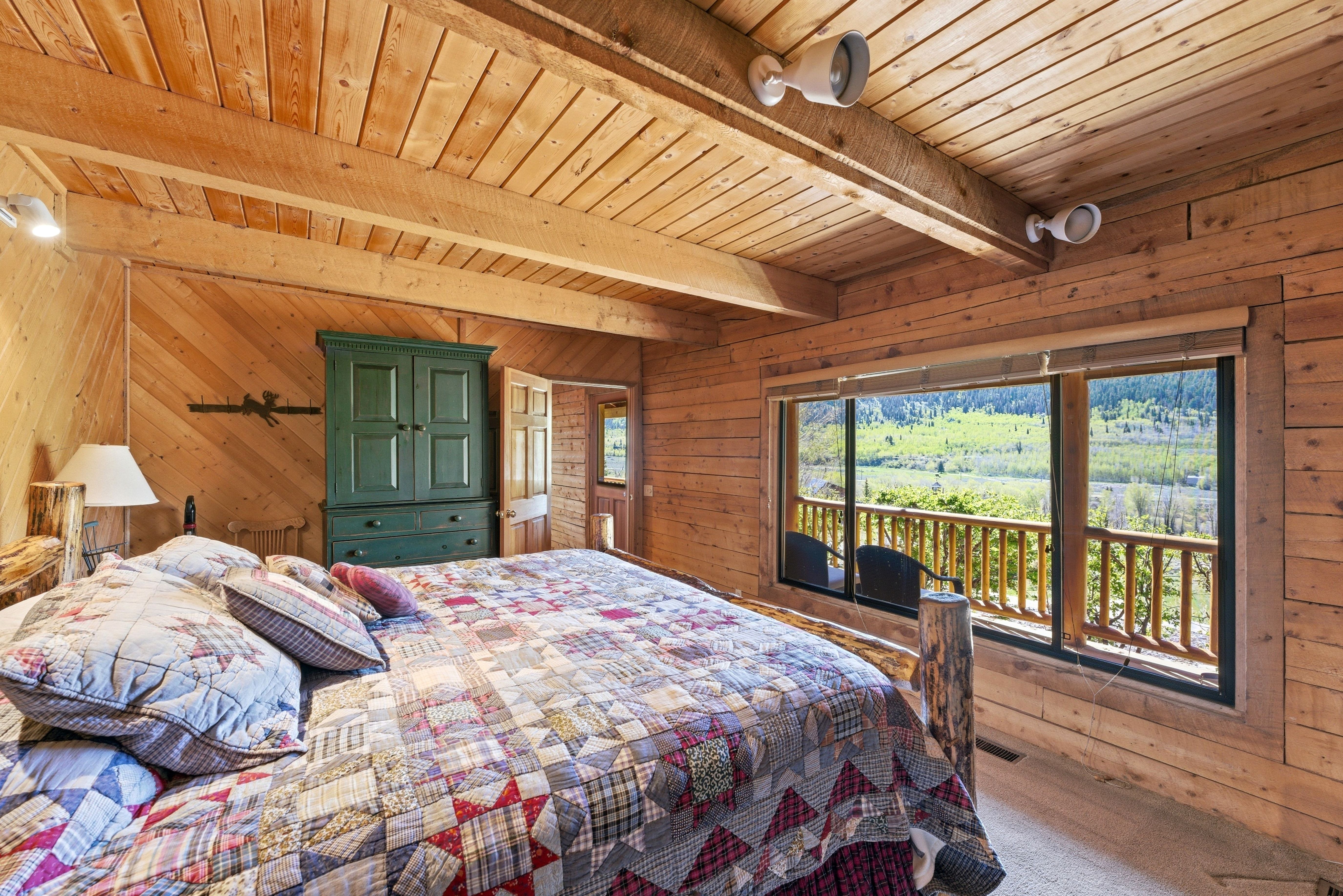 Expansive window with roller shade overlooking a verdant mountain landscape