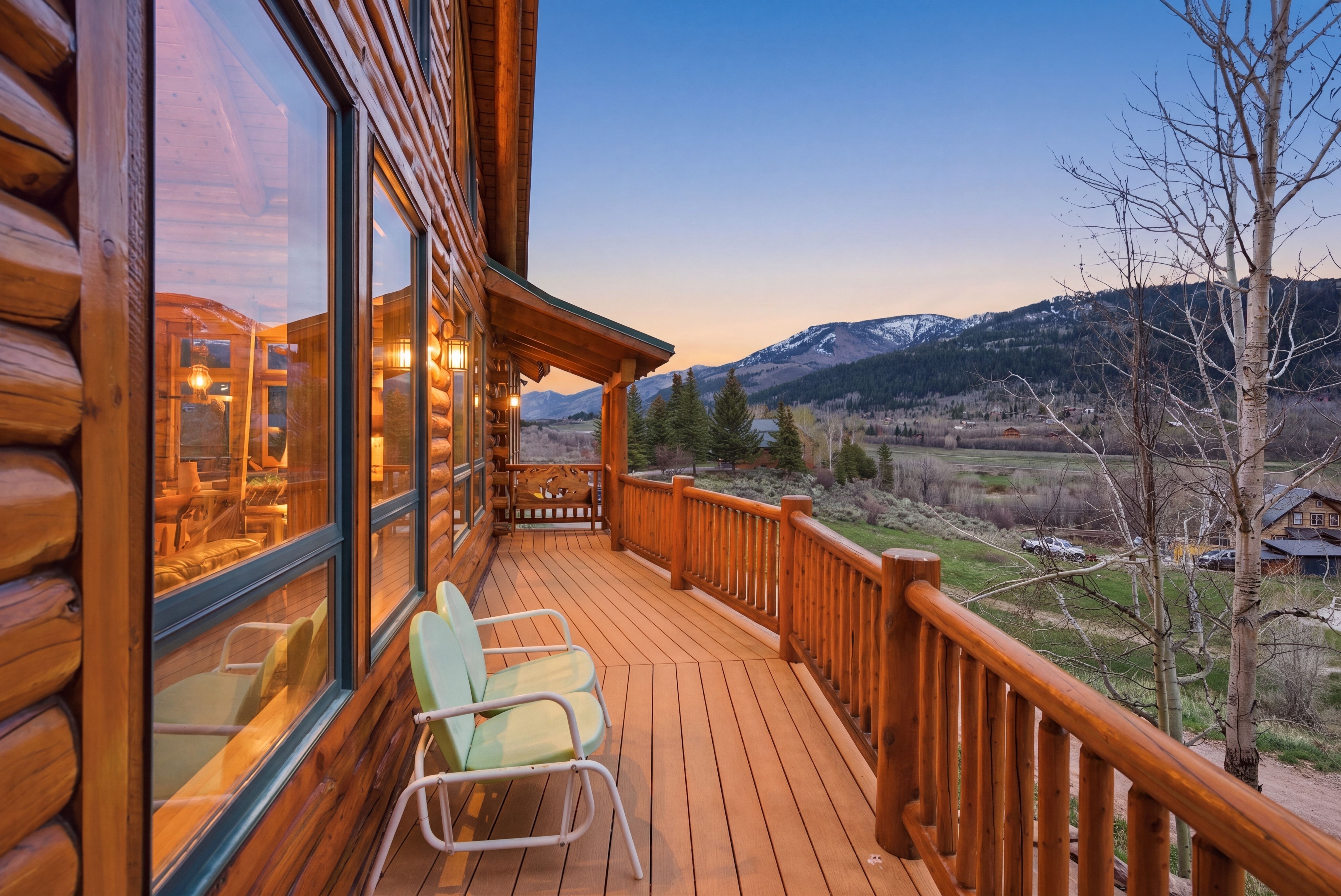 Expansive outdoor deck featuring wood-finish flooring and log railing