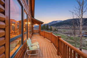 Expansive outdoor deck featuring wood-finish flooring and log railing