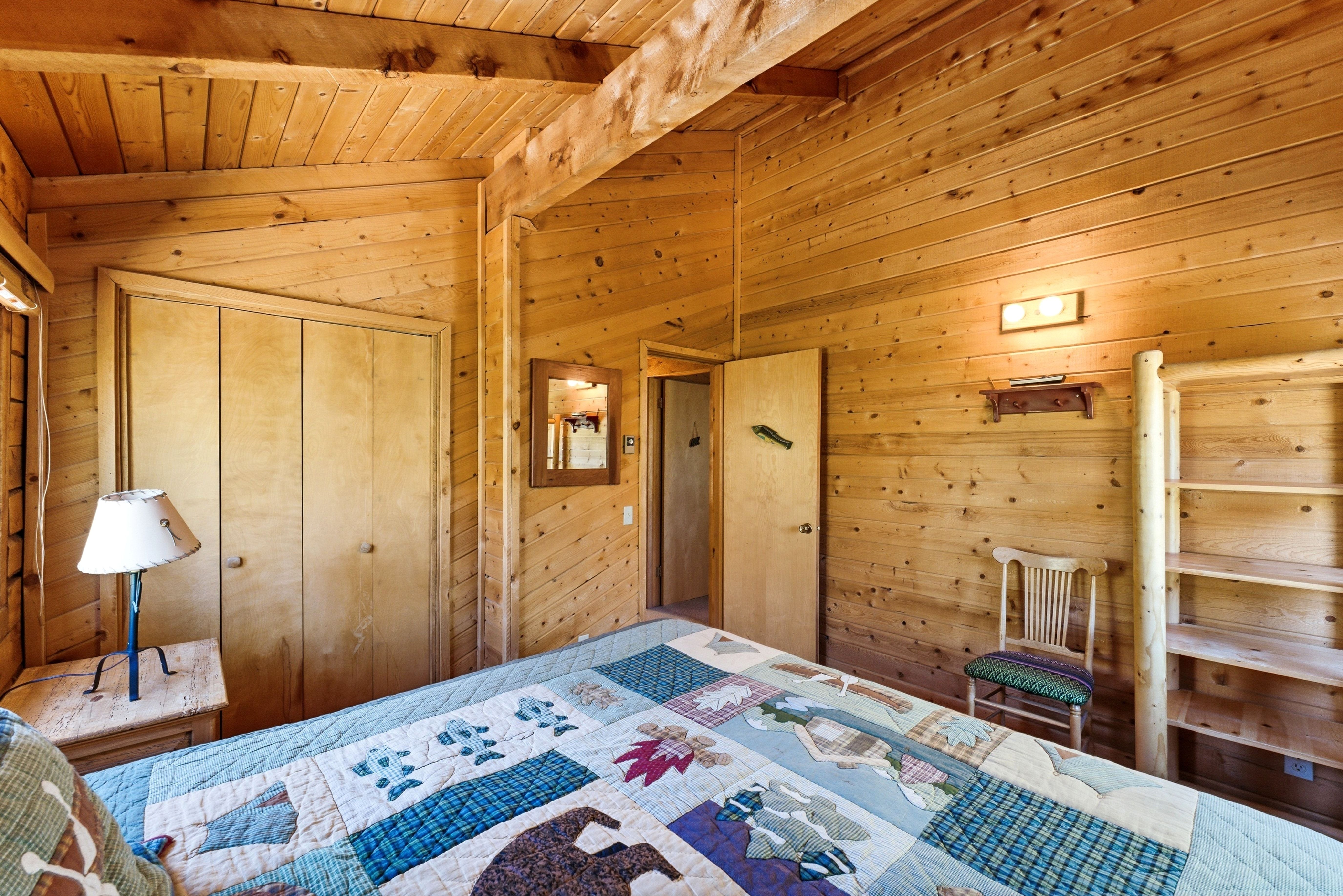 Wood-paneled room featuring a vaulted wood-beam ceiling, built-in shelving, and a double-door closet