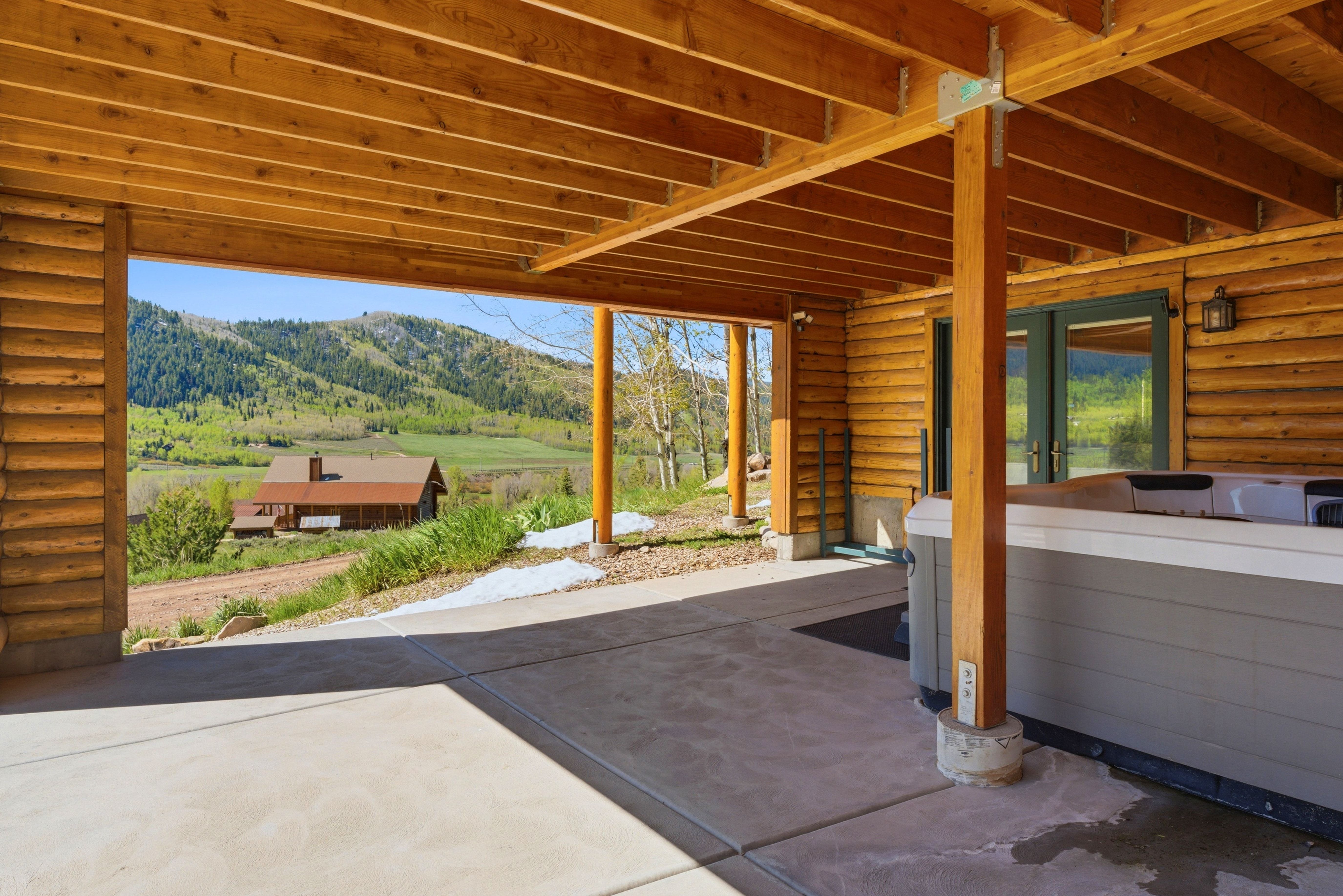 Covered outdoor patio with a concrete surface and a built-in spa