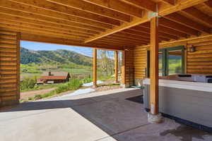 Covered outdoor patio with a concrete surface and a built-in spa
