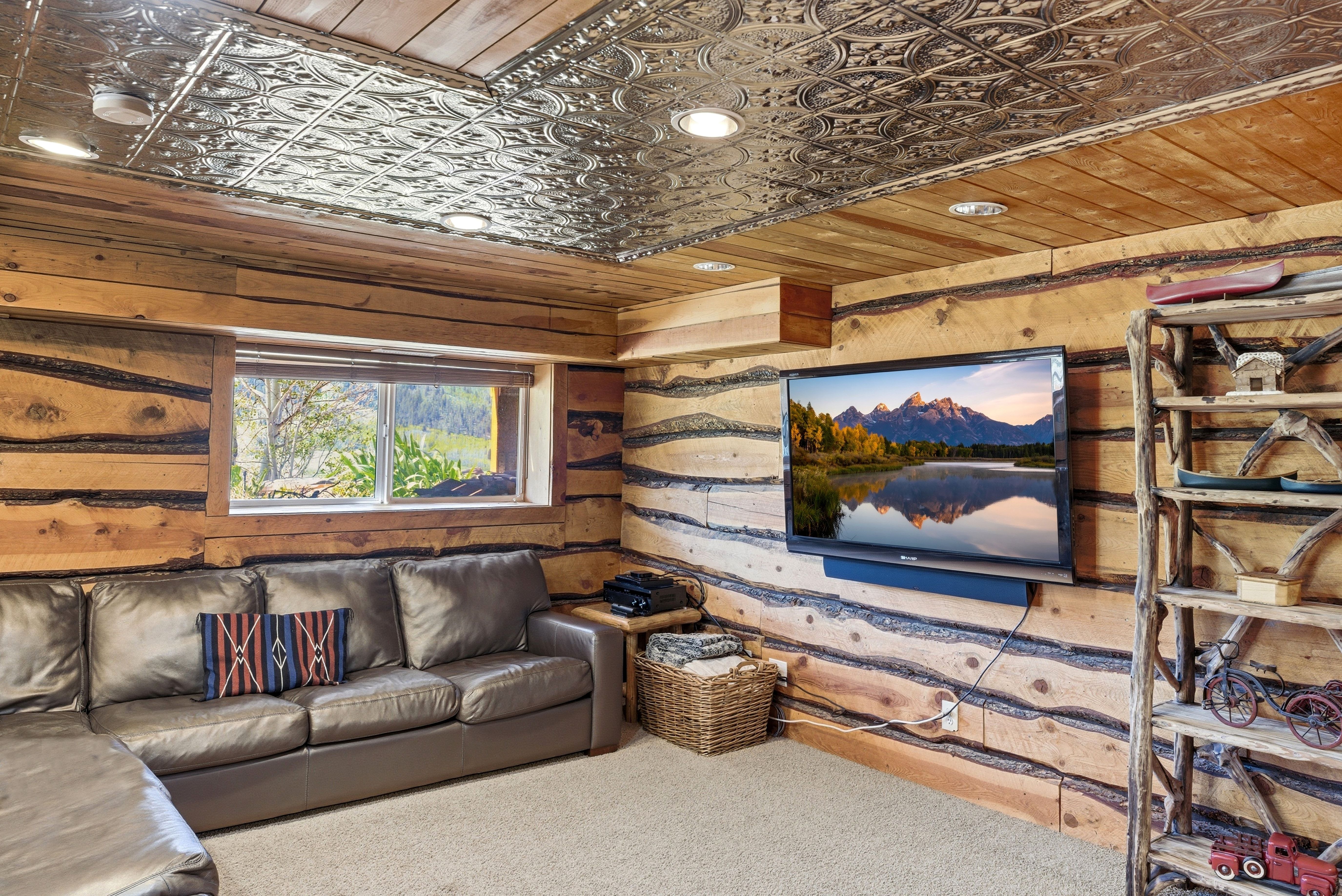 Interior space featuring natural wood walls, a decorative tin ceiling, recessed lighting, and a window with exterior visibility