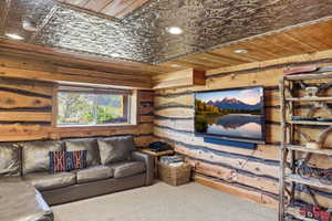 Interior space featuring natural wood walls, a decorative tin ceiling, recessed lighting, and a window with exterior visibility