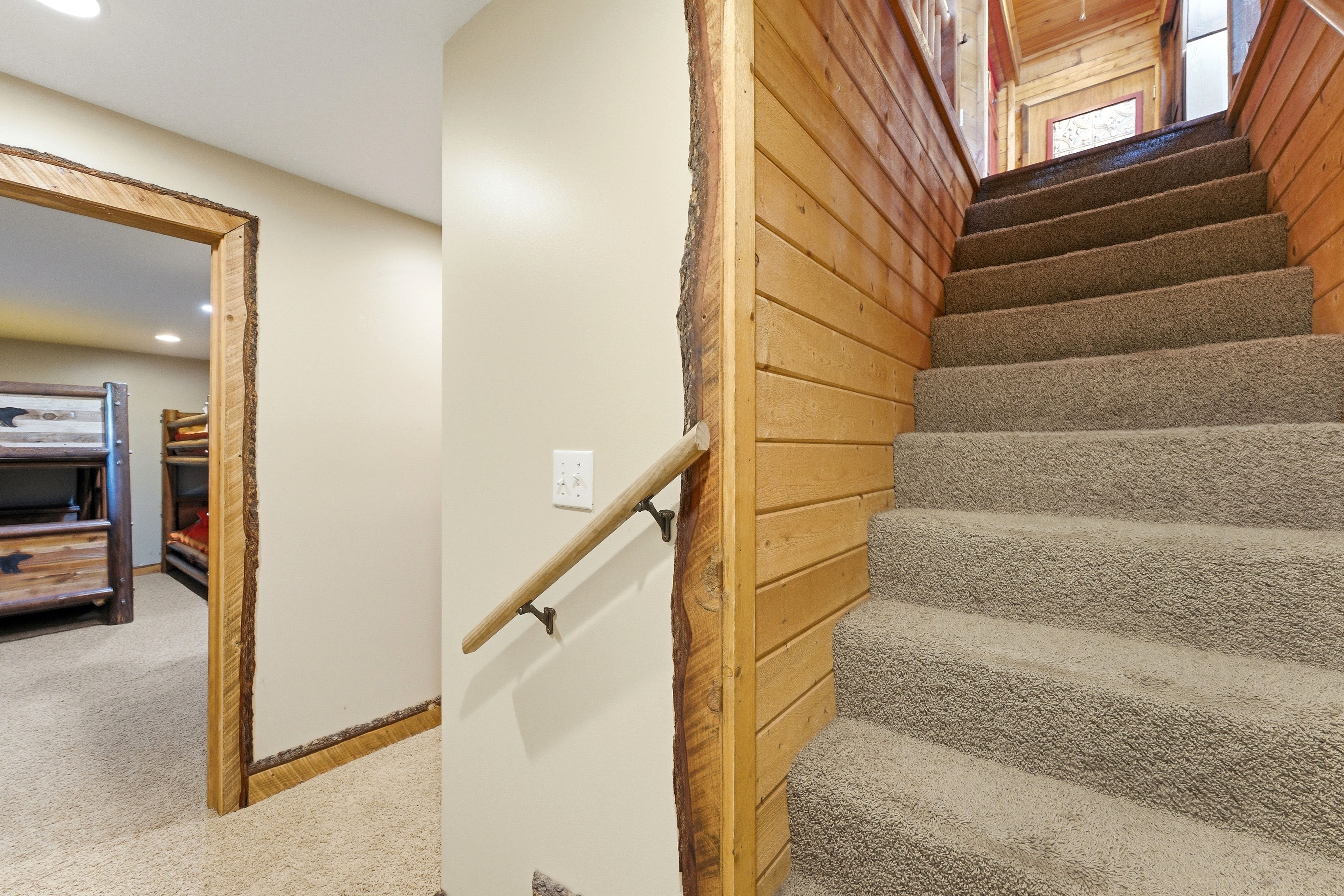 Carpeted staircase with wood plank wall and natural edge wood trim
