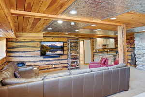 Recreational room featuring wood-finish walls and ceiling, recessed lighting, and a partial tin-panel ceiling