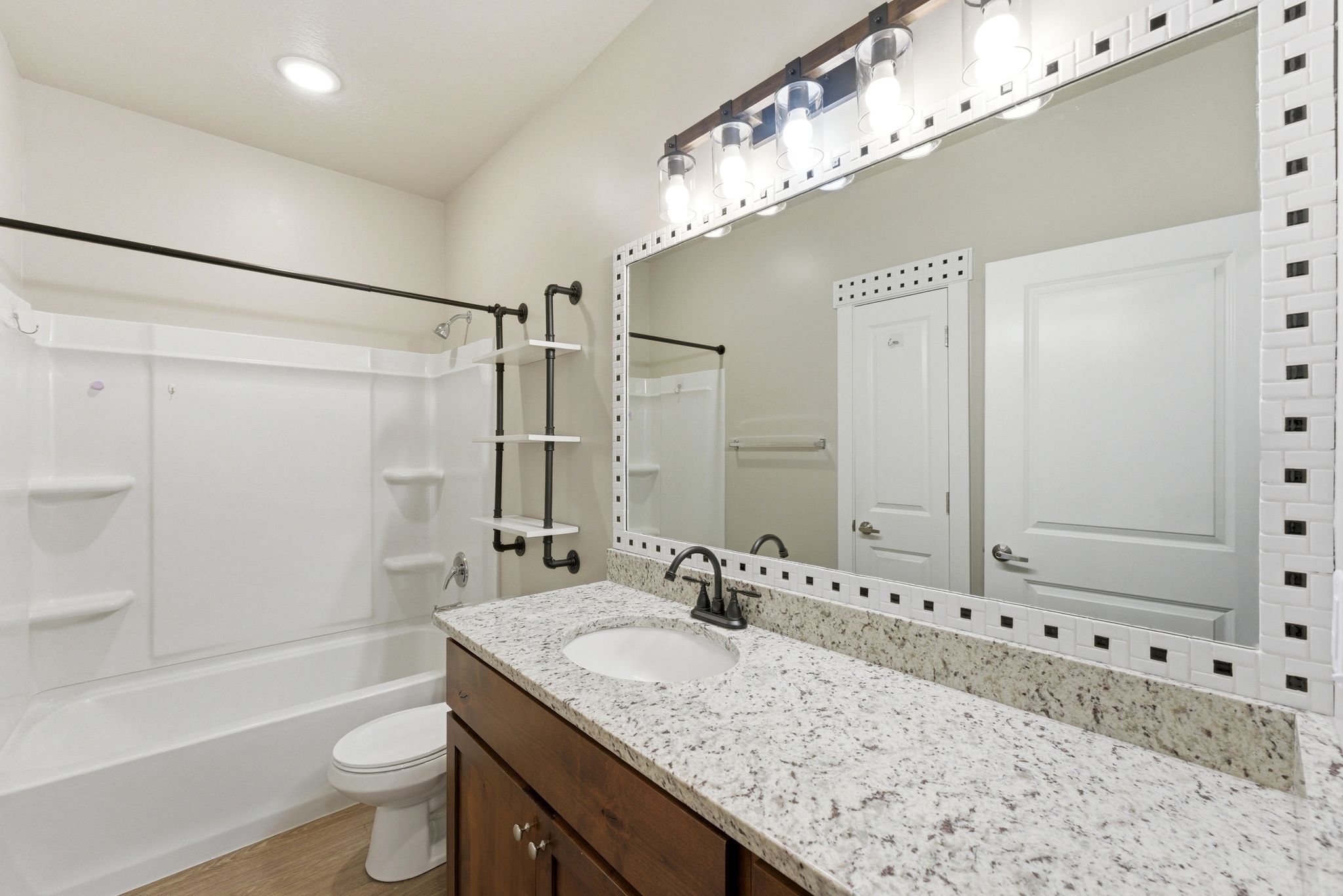 Bathroom featuring a single vanity with a light-colored countertop and a dark wood-finish cabinet