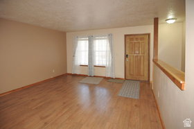 Entryway featuring wood-finish flooring, a solid wood entry door, and a half-wall partition