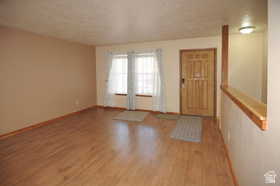 Entryway featuring wood-finish flooring, a solid wood entry door, and a half-wall partition