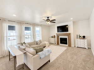 Spacious living area featuring a fireplace with a wood mantle and tile surround, recessed lighting, and multiple windows