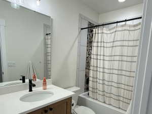 Bathroom featuring a wood-finish vanity with a white countertop, an undermount sink, and a black faucet