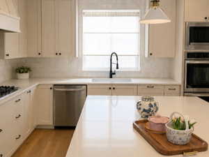 Kitchen featuring wood-finish flooring, recessed lighting, and a kitchen island with a light-toned countertop