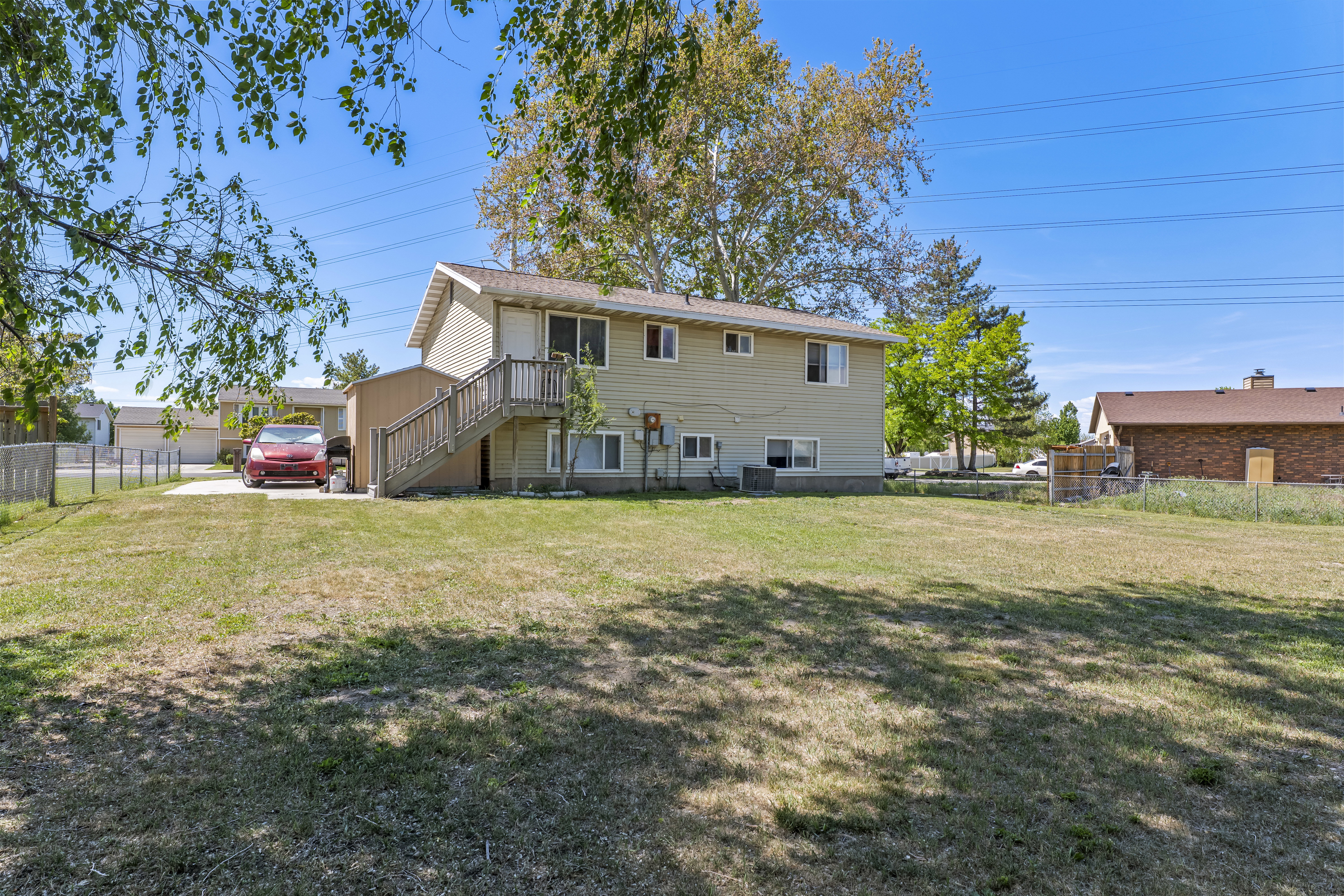Expansive rear yard featuring natural grass and mature trees