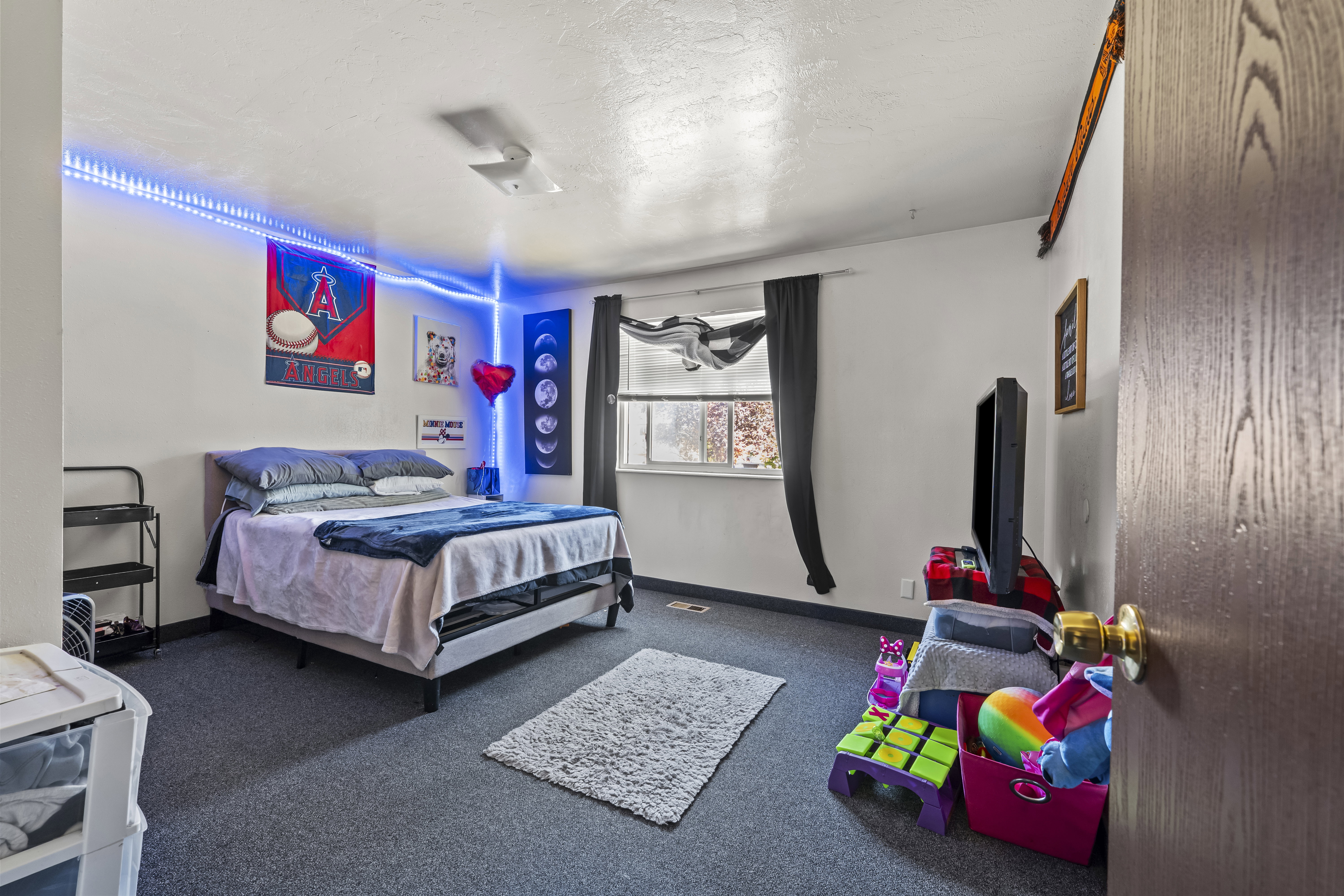 Room featuring wall-to-wall carpeting and a window with dark drapes