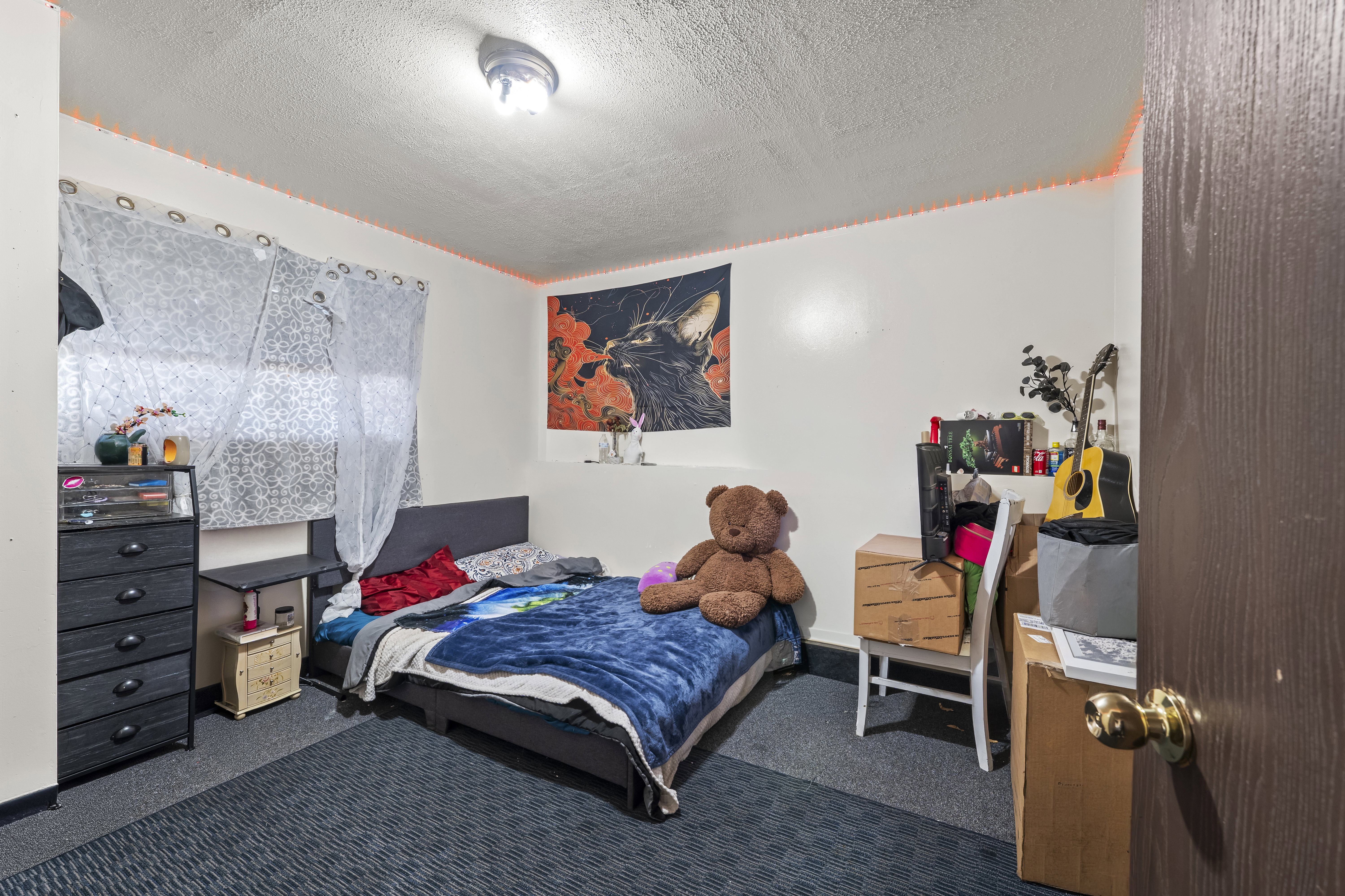 Carpeted room featuring a ceiling-mounted light fixture and a textured ceiling