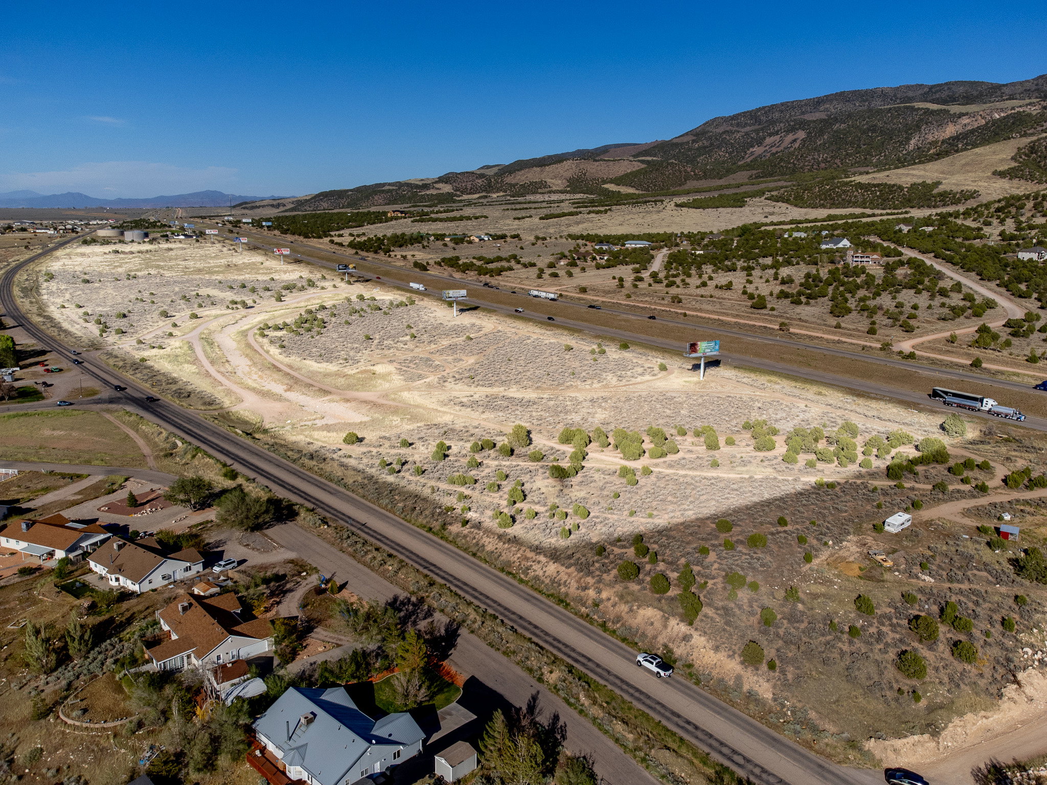 Expansive undeveloped land featuring direct highway frontage and mountain backdrop