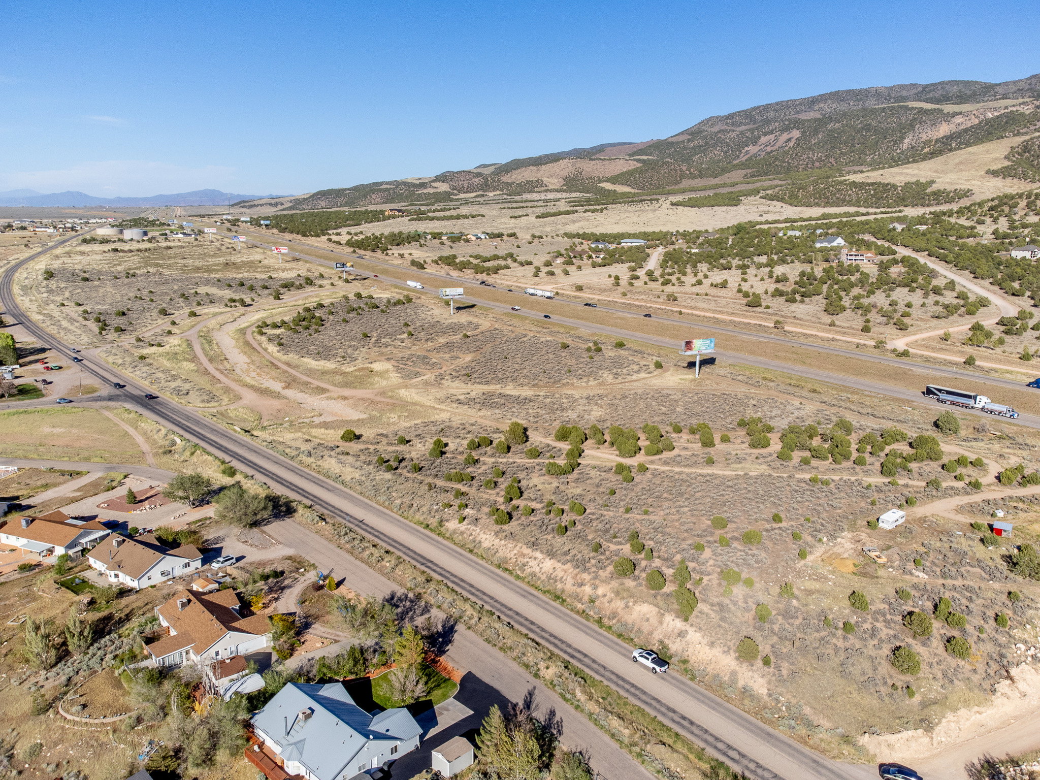 Expansive undeveloped land featuring natural desert vegetation, rolling hills, and distant mountain backdrops