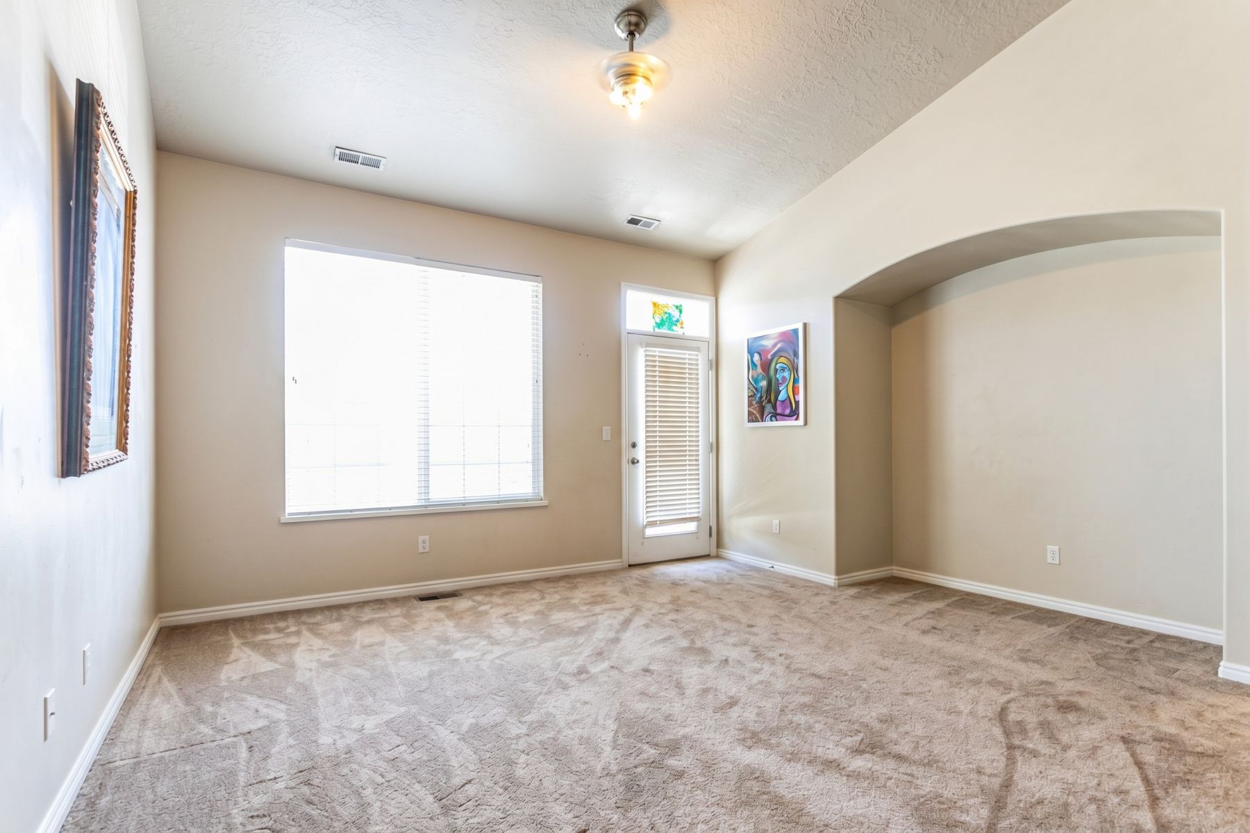 Furniture Removed by AI. Spacious room featuring neutral carpeting and light-colored walls