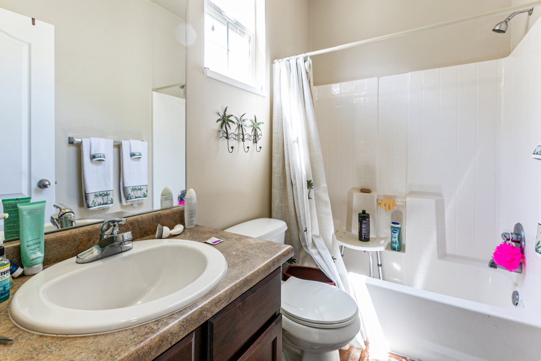Bathroom featuring an integrated sink with a chrome faucet, dark wood-finish vanity, and a shower-tub combination with a white surround