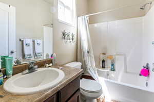 Bathroom featuring an integrated sink with a chrome faucet, dark wood-finish vanity, and a shower-tub combination with a white surround