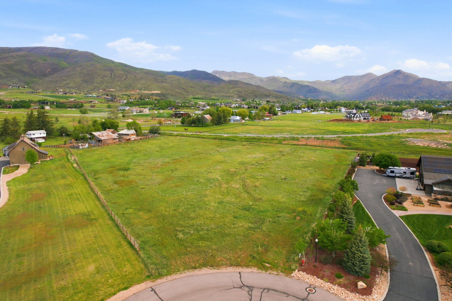 Expansive green land parcel featuring distant mountain ranges