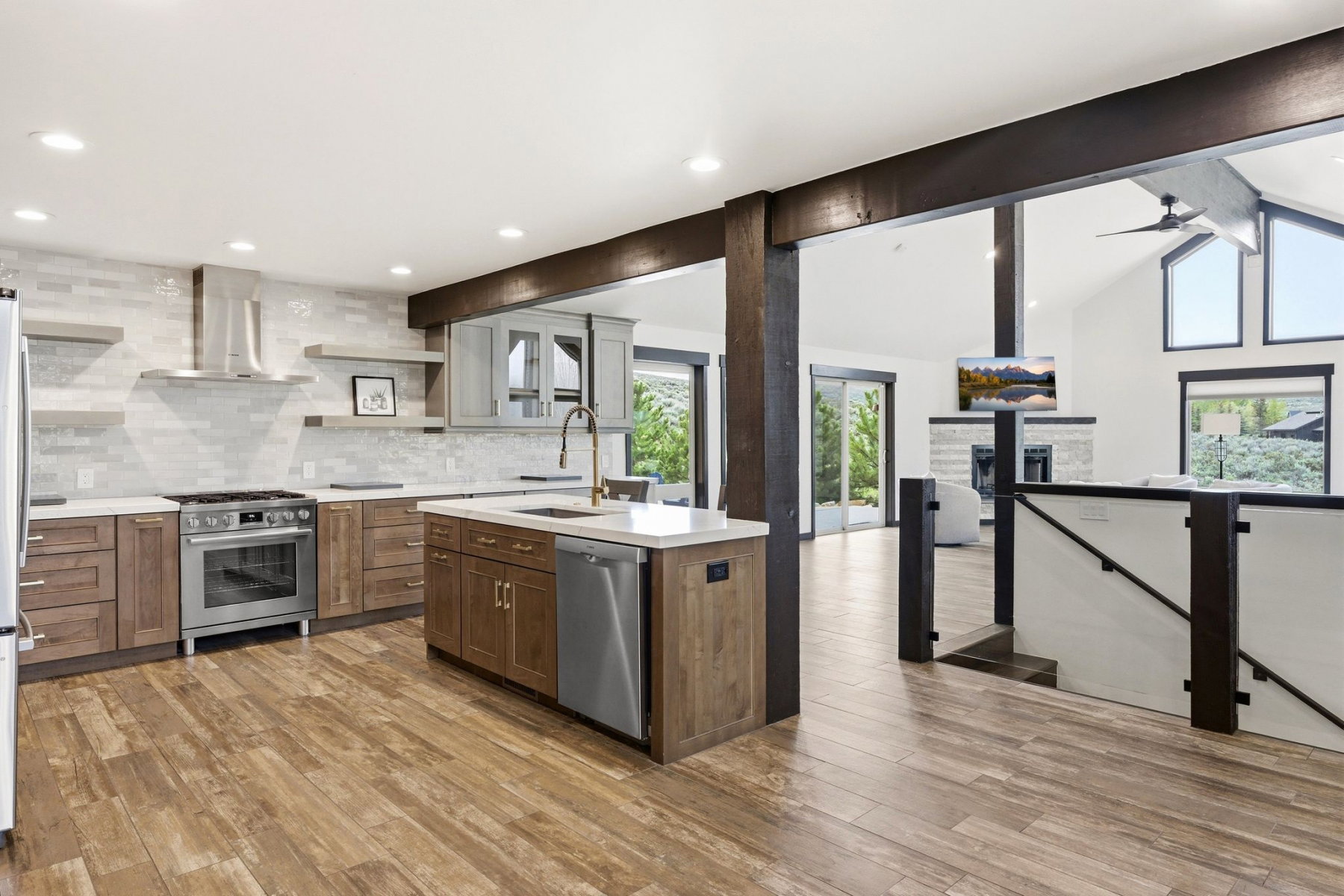 Contemporary kitchen featuring wood-finish flooring, white countertop surfaces, and stainless steel appliances