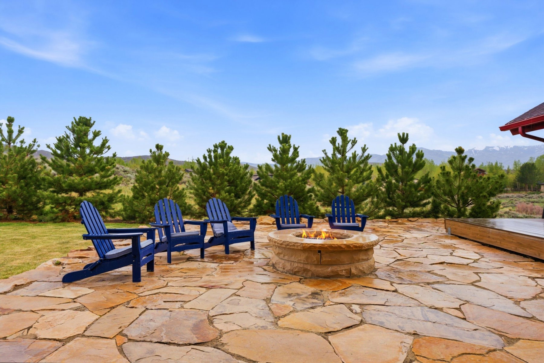 Expansive flagstone patio featuring a built-in stone fire pit