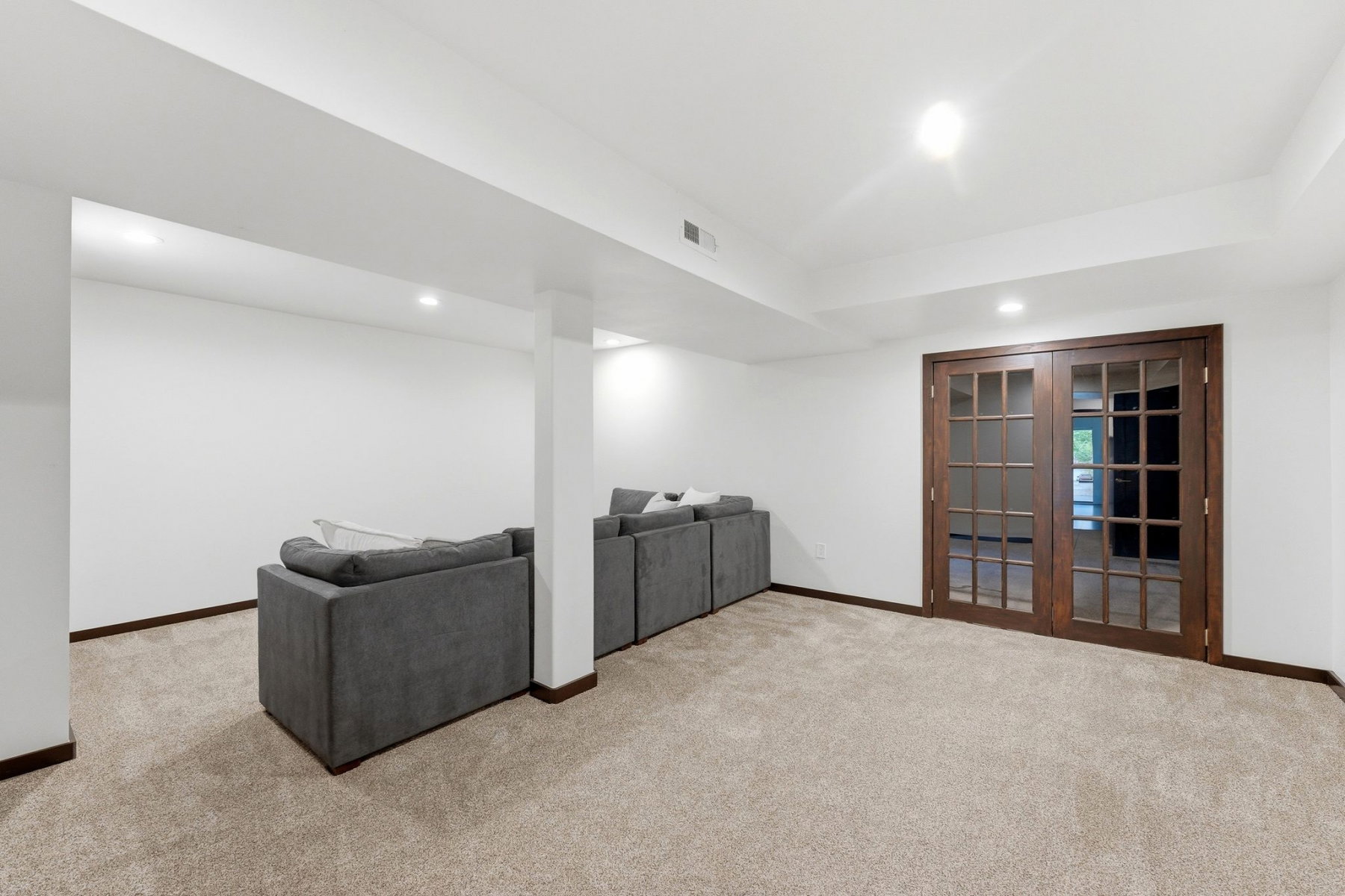 Spacious room featuring neutral carpet flooring, recessed lighting, and white walls