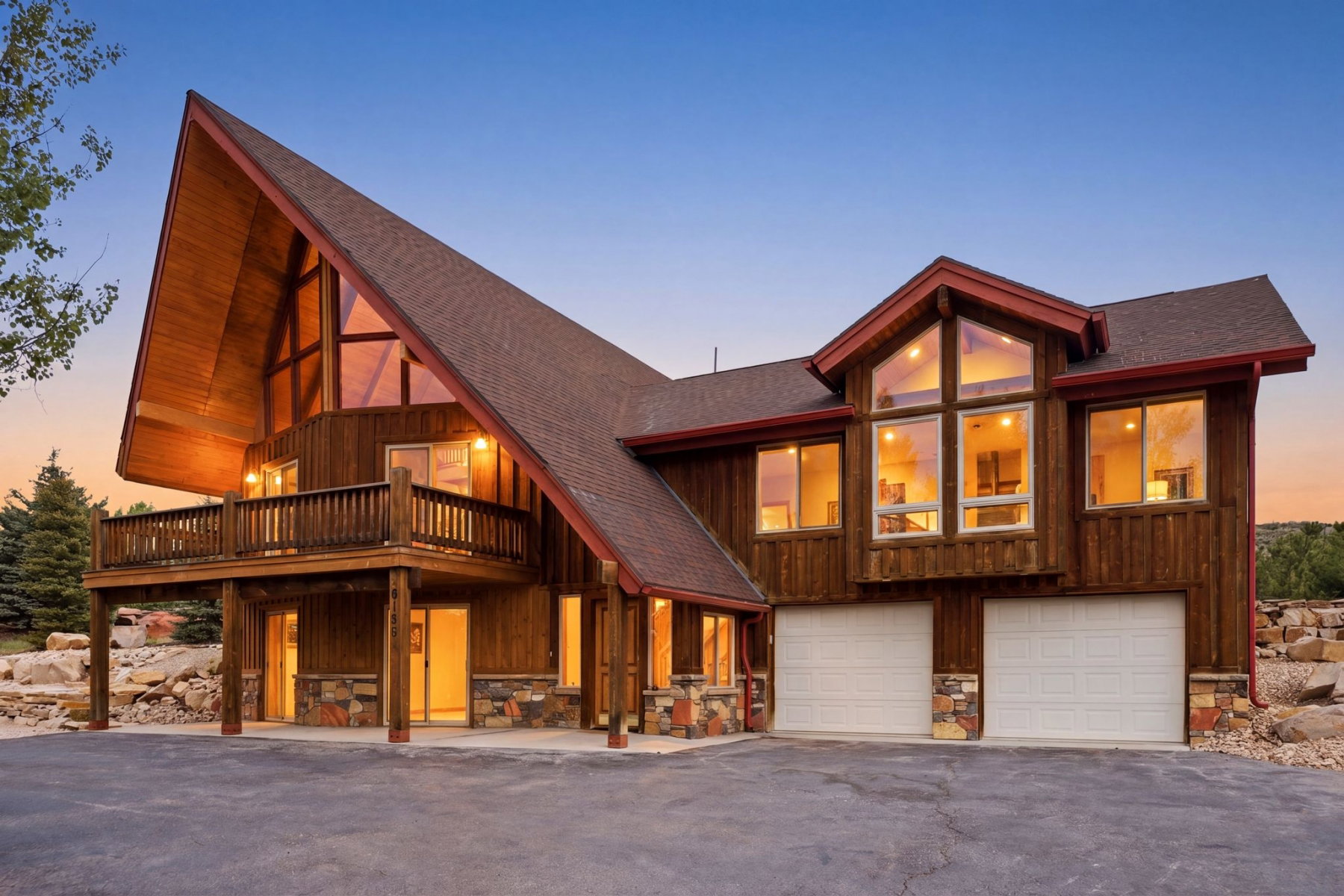 Striking A-frame architecture featuring extensive wood siding, multiple large windows, a spacious upper-level balcony, a two-car garage, and stone accents