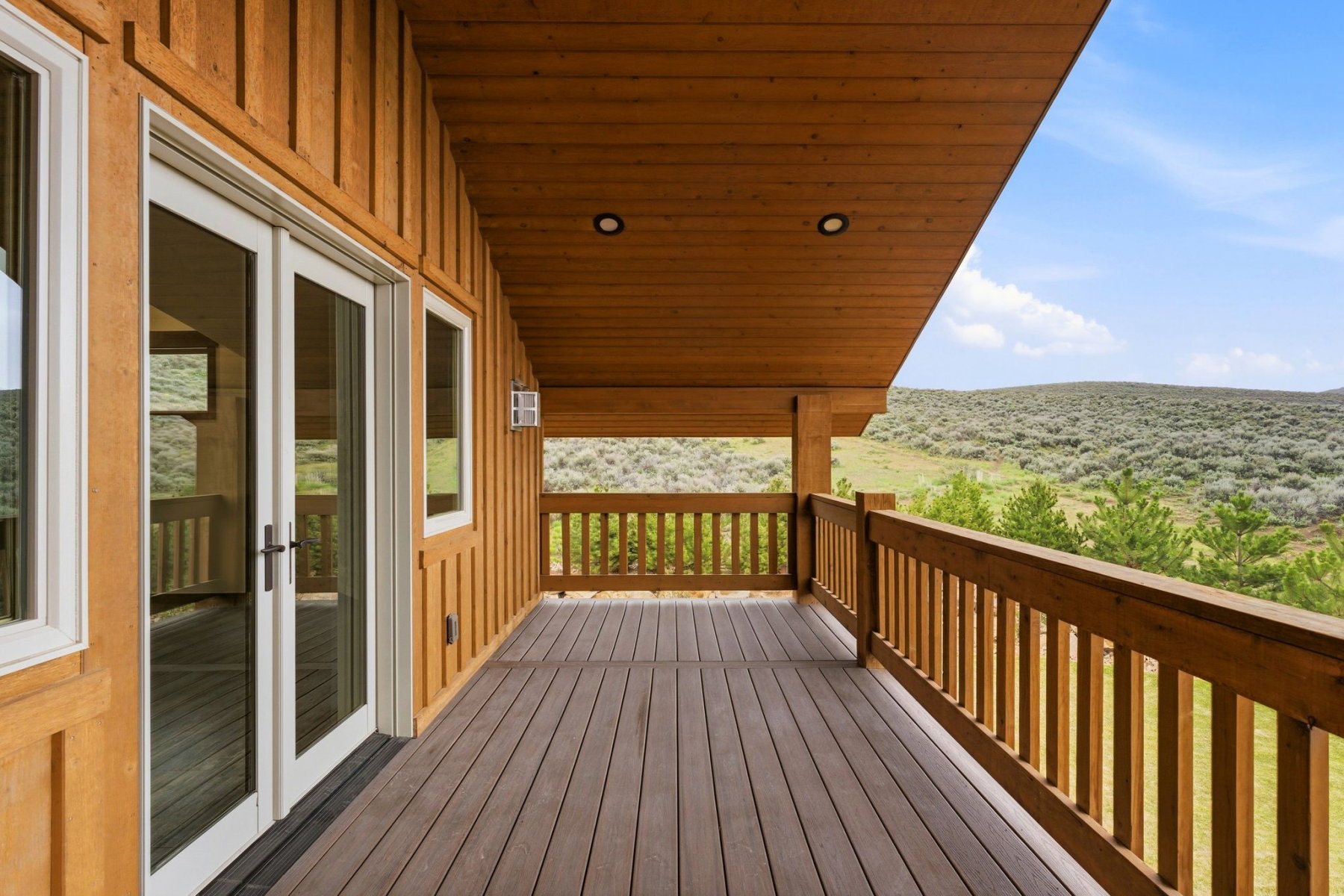 Covered outdoor deck featuring wood-finish siding, wood-finish ceiling, and wood-finish railing