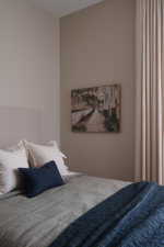 Warm-toned walls accenting a textile headboard, with full-height drapery panels providing natural light control