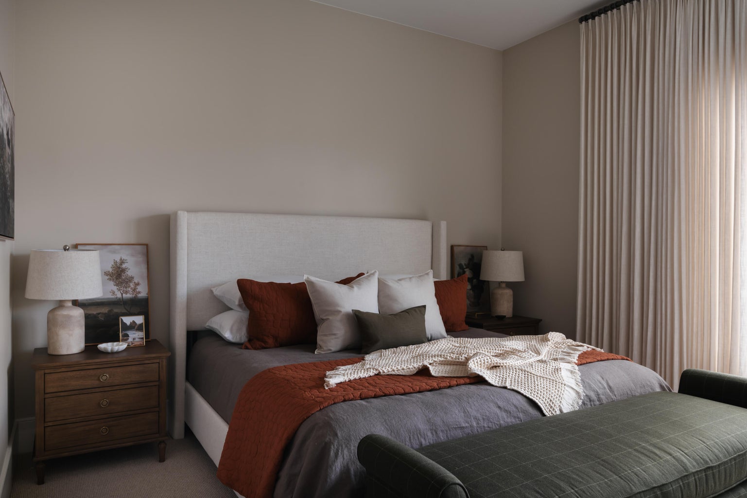 Spacious room featuring a neutral wall color, full-height window drapery, and textured headboard