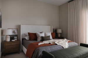 Spacious room featuring a neutral wall color, full-height window drapery, and textured headboard