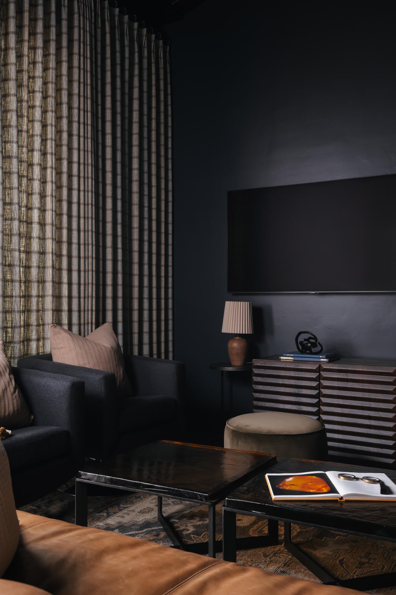 Living area with dark walls and full-height patterned drapery