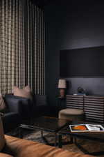 Living area with dark walls and full-height patterned drapery
