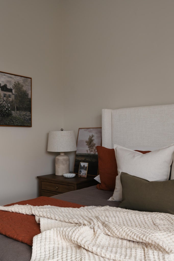Upholstered headboard with an adjacent wood-finish nightstand