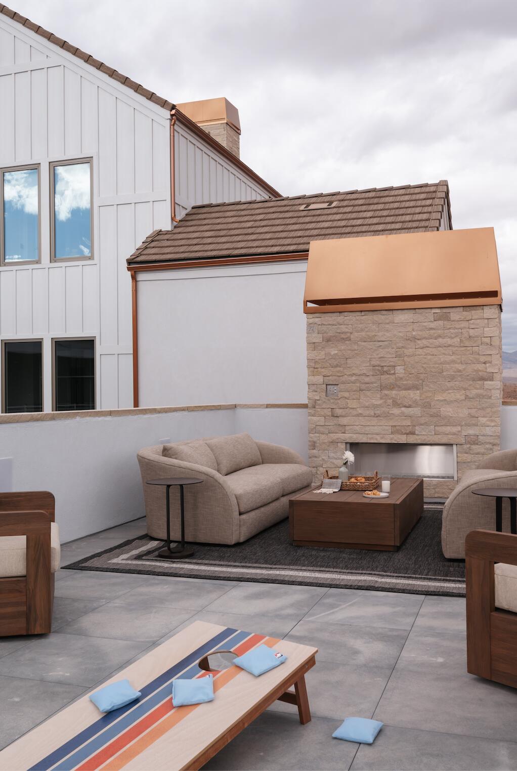 Rooftop patio with concrete flooring, a built-in stone fireplace, and a low privacy wall