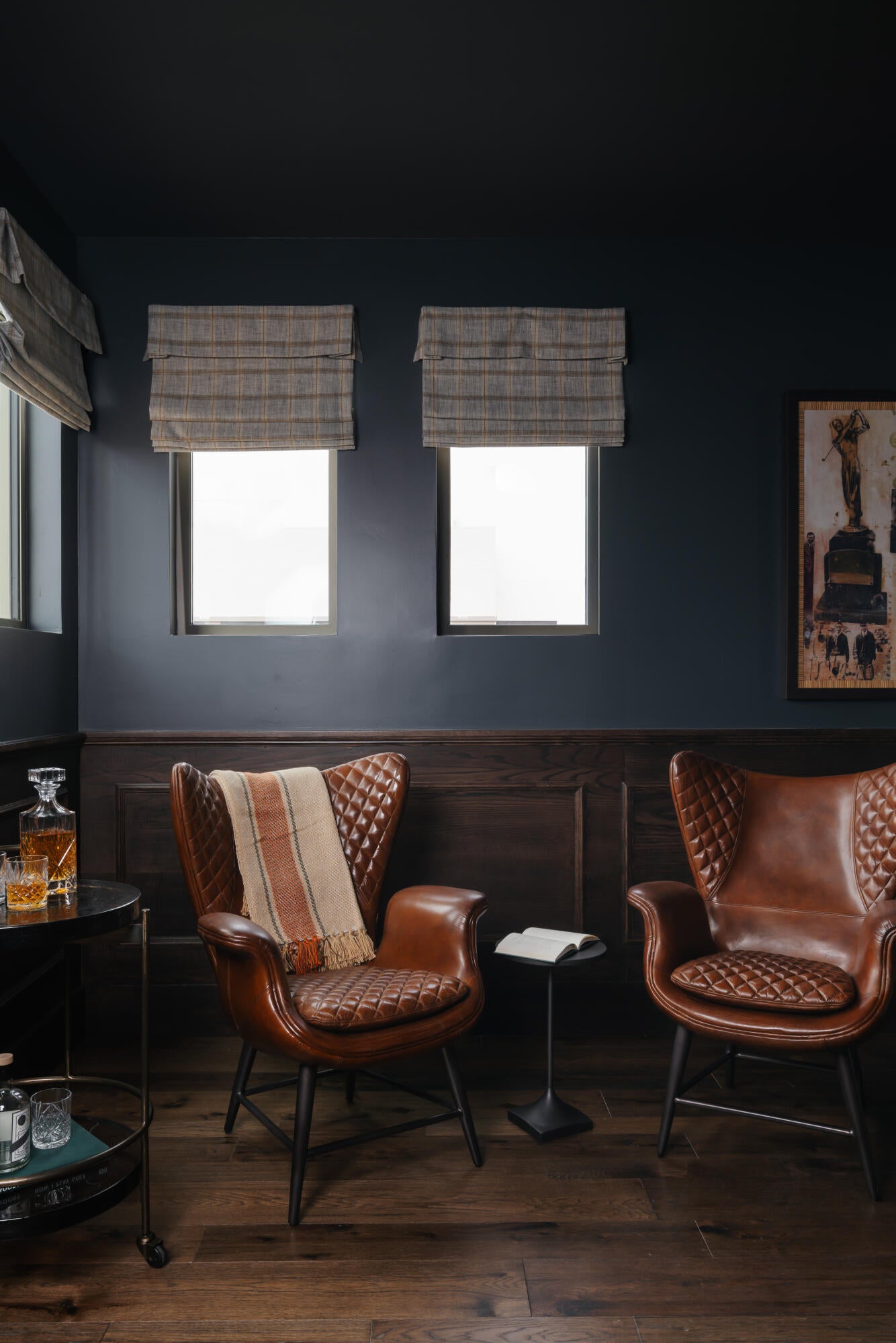 Rich wood-finish flooring complements dark wainscoting and deep-toned walls