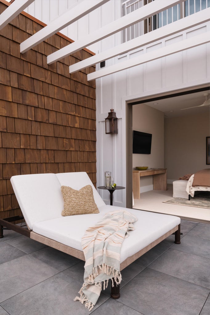 Private outdoor patio featuring a cedar shake accent wall and white pergola