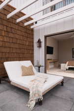 Private outdoor patio featuring a cedar shake accent wall and white pergola