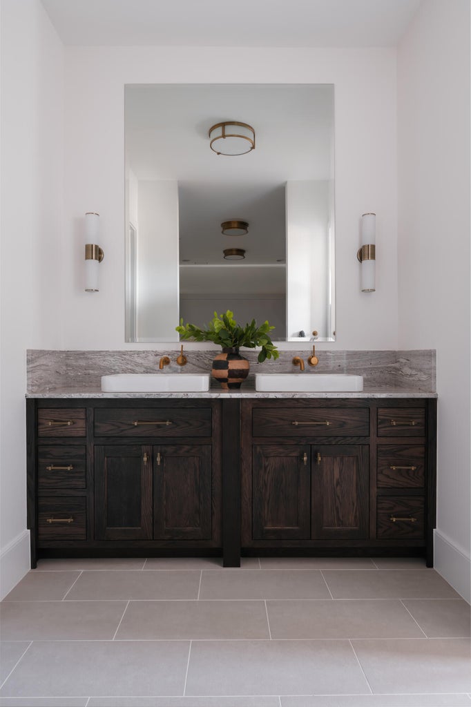 Dual vanity featuring dark wood cabinetry, light stone countertop, and two rectangular vessel sinks