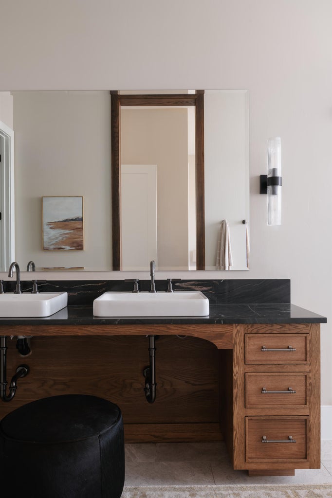 Double vanity with dark wood cabinetry, rectangular vessel sinks, and dark stone countertop