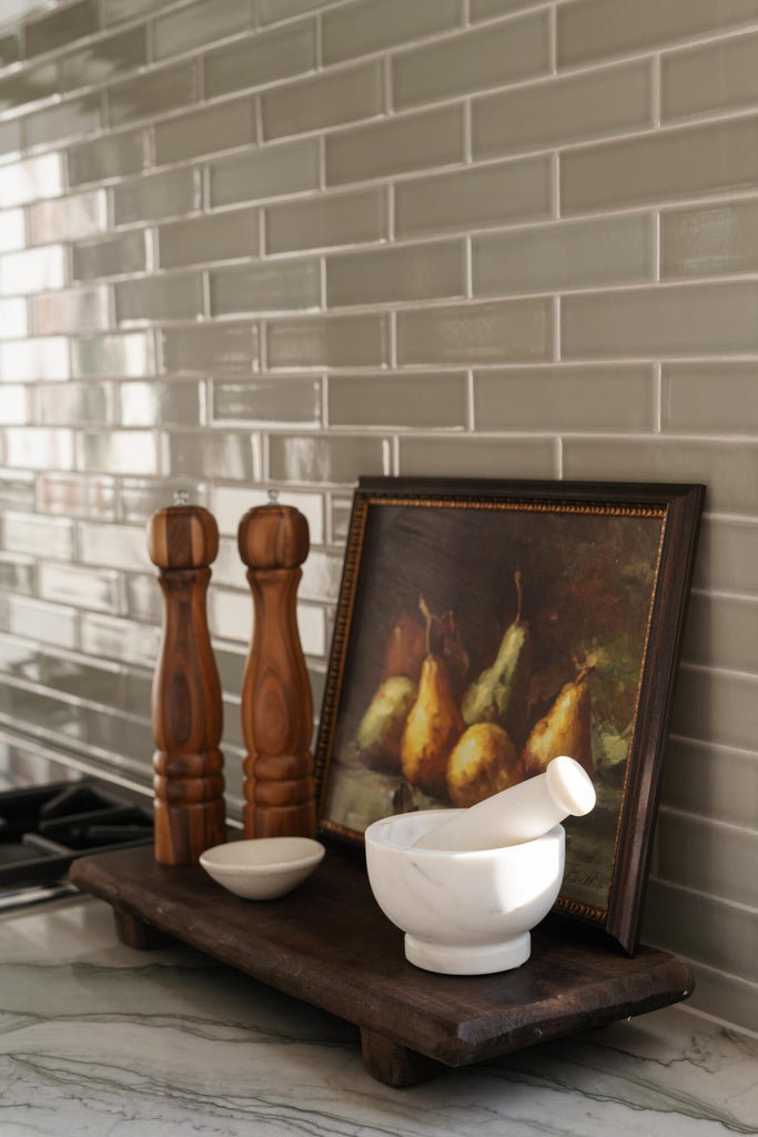 Subway tile backsplash in a neutral tone with a light gray grout, complemented by a stone-finish countertop